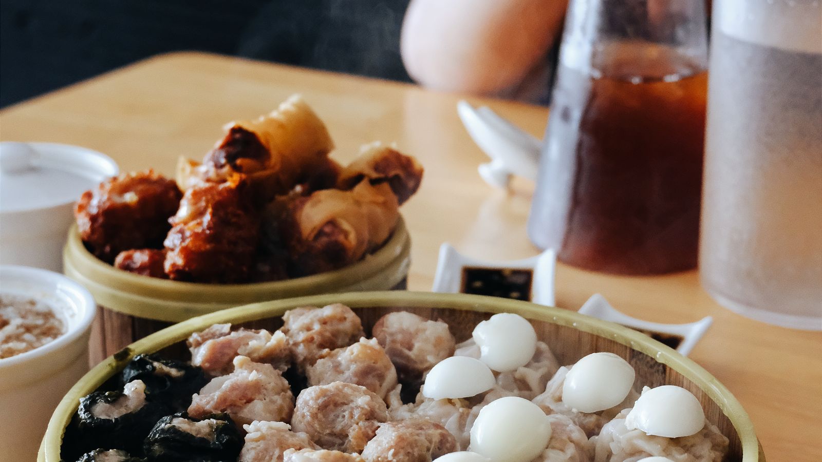 A spread of Chinese dishes with tea at a restaurant table