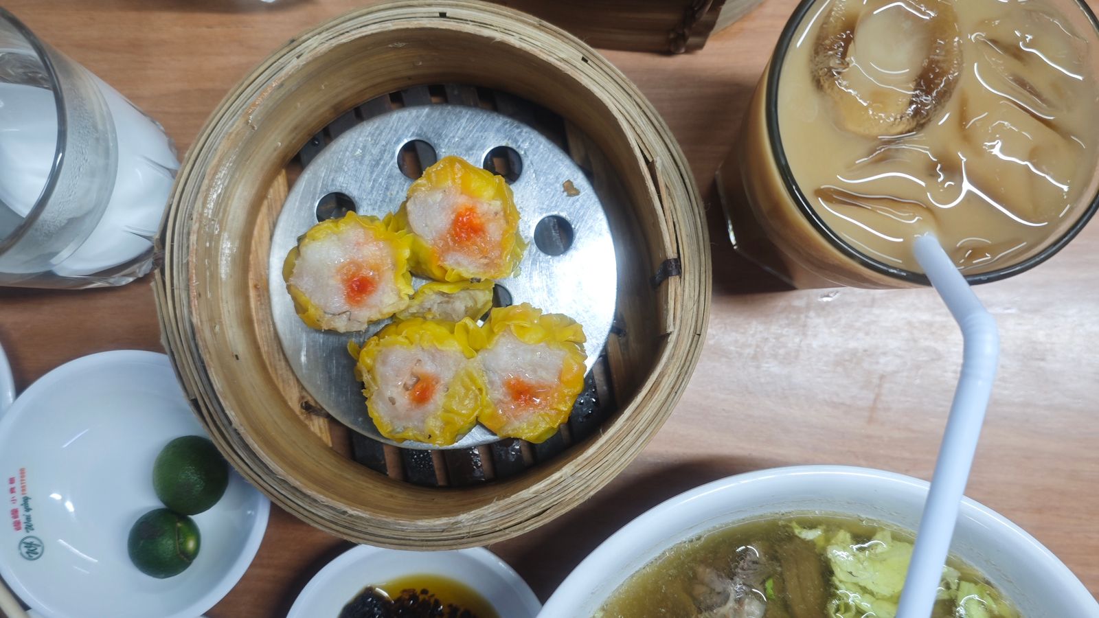 Shumai in a bamboo steamer with milk tea, a classic yum cha spread
